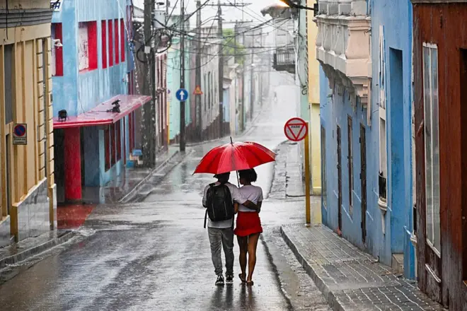 زوجان يسيران في أحد شوارع مدينة سانتياغو دي كوبا قبل وصول الإعصار ميليسا إلى المدينة في 28 أكتوبر/تشرين الأول 2025.