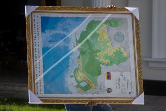 Homem carrega Mapa da Venezuela com a região da Guiana anexada