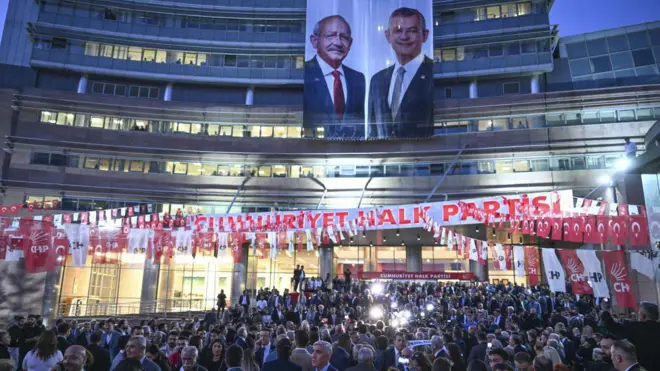 CHP merkez binasının önünde çoğu resmi giyimli yüzlerce kişi var, binanın üst katlarında Kılıçdaroğlu ve Özel'in posteri yanyana sarkıyor. 