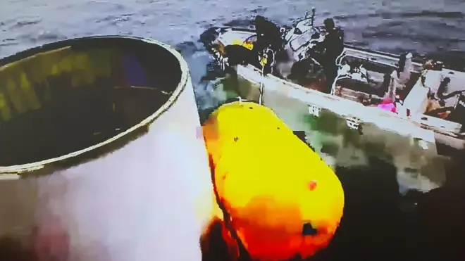 북한이 주장하는 우주 발사체 일부를 인양 중인 모습