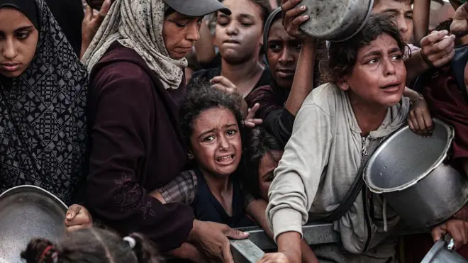 Голодні жінки й діти в черзі за роздачею харчів 