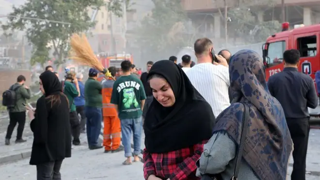 Una mujer llora afuera de un edificio dañado en un ataque