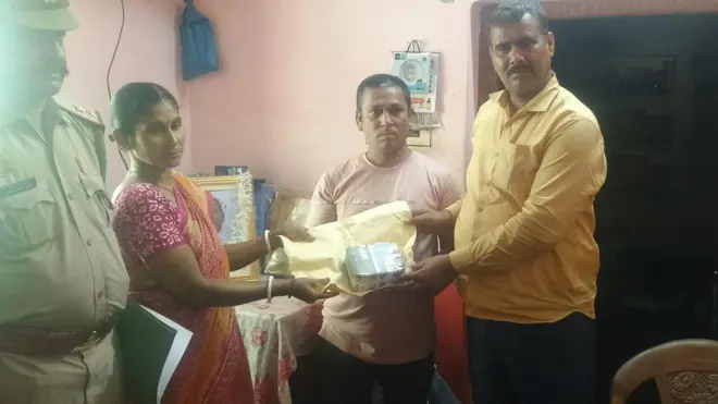 कुंभ भगदड़ में मारे गए विनोद रुइदास के परिवार को पांच लाख रुपए कैश देते हुए उत्तर प्रदेश पुलिस 