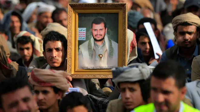يحمل يمني شيعي صورةً للزعيم الحوثي عبد الملك الحوثي، أثناء استماعه لخطابٍ ألقاه خلال مراسم إحياء ذكرى عاشوراء في صنعاء، بتاريخ 25 يونيو/حزيران 2026. وتشمل مراسم عاشوراء فترة حدادٍ مدتها عشرة أيام تبدأ في أول أيام شهر محرم حسب التقويم الهجري، إحياءً لذكرى استشهاد الإمام الحسين، حفيد النبي محمد، في القرن السابع الميلادي.