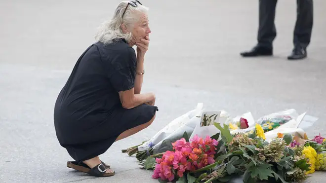 बोंडी बीच हमले में जान गंवाने वालों को श्रद्धांजलि देती एक महिला