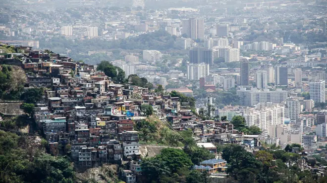 Foto panorâmica mostra favela e prédios atrás, no Rio