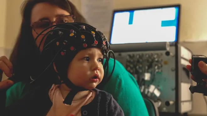A baby girl has her brain scanned while playing a game that tests her brain development