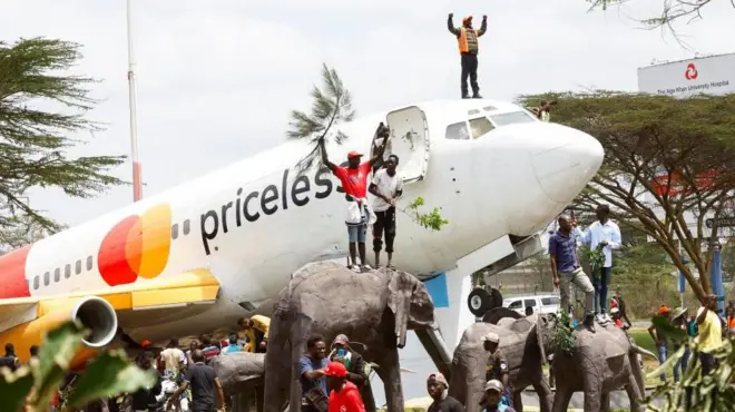 Abagandaye bahagaze ku ndege iri hasi n'ibishushanyo vy'inzovu

