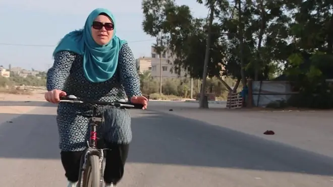 الفلسطينية آمنة سليمان تشعر بطعم الحرية وهي تركب دراجتها الهوائية في شوارع مخيم جباليا في قطاع غزة غير آبهة بالعادات والتقاليد المحافظة.