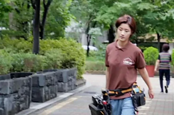 工具をもって歩く女性