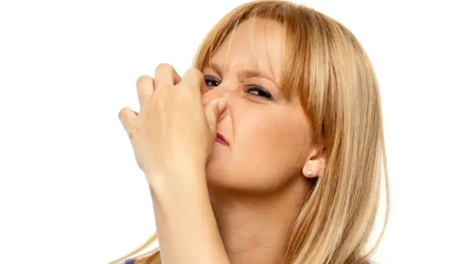 নাক চেপে ধরা নারী