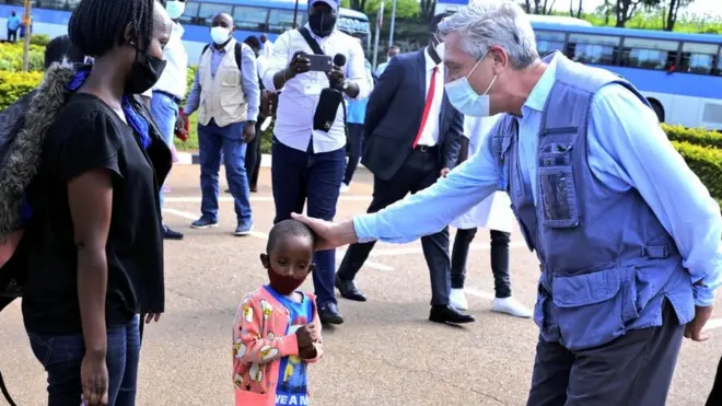 Filippo Grandi (iburyo) ku mupaka wa Gasenyi - Nemba hamwe n'umwe mu muryango watahutse