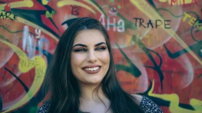 Nasmejana Ana Ilić ispred šarenog zida 