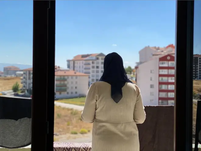 Une femme regardant depuis un balcon