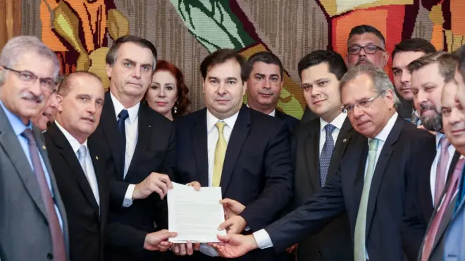 Entre outros membros do Executivo e do Legislativo, o presidente Jair Bolsonaro, o presidente da Câmara, Rodrigo Maia, e o ministro da Economia, Paulo Guedes, mostram primeiro documento com proposta da reforma