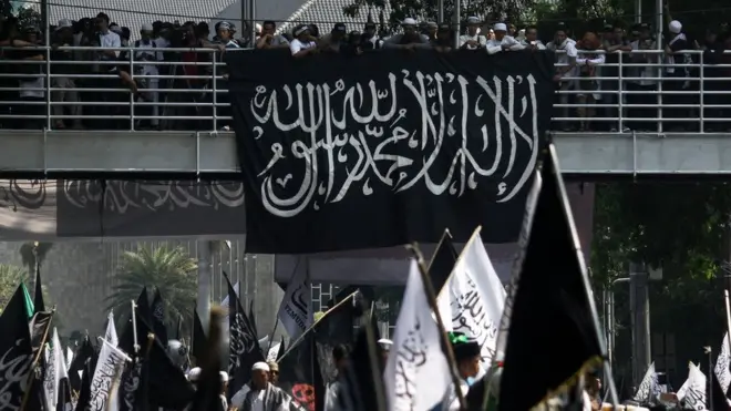 Sejumlah orang membawa bendera bertuliskan Tauhid dalam aksi demonstrasi di Jakarta pada 26 Oktober 2018.