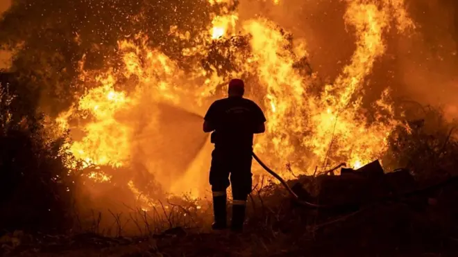 Bombeiro combate incêndio florestal na Grécia