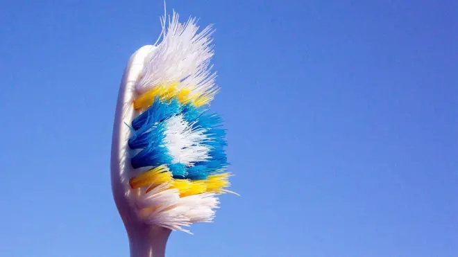 Зубна щітка на блакитному тлі