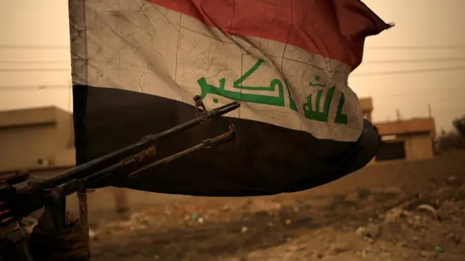 Iraqi flag seen during a sand storm in Bartella, east of Mosul, Iraq (1 November 2016)