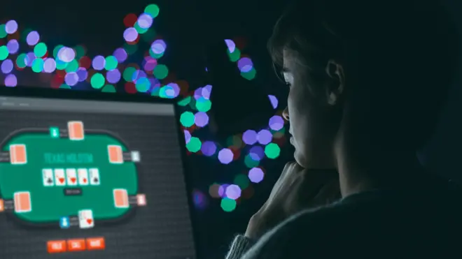 Çevrimiçi poker oynarken ekrana bakan bir kadın