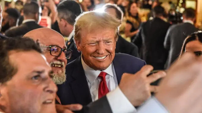 Donald Trump poses with patrons during a surprise visit to the Versailles restaurant in Little Havana, Miami, after pleading not guilty in court