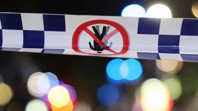 Police tape is stretched near a crime scene