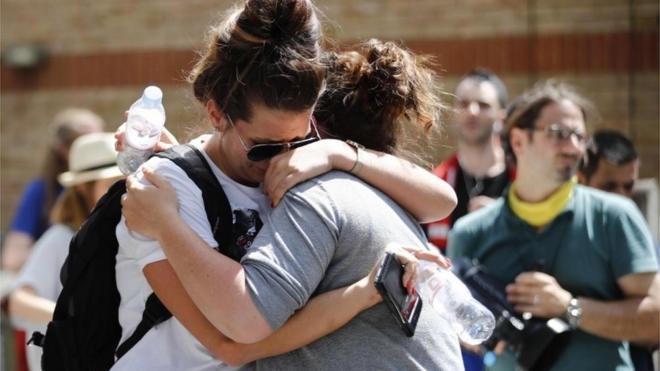 Mujeres se abrazan y lloran en la zona de la Torre Grenfell, edificio calcinado en Londres