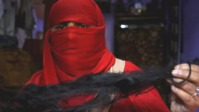 ایک خاتون کی اپنے کٹے ہوئے بال کے ساتھ تصویر