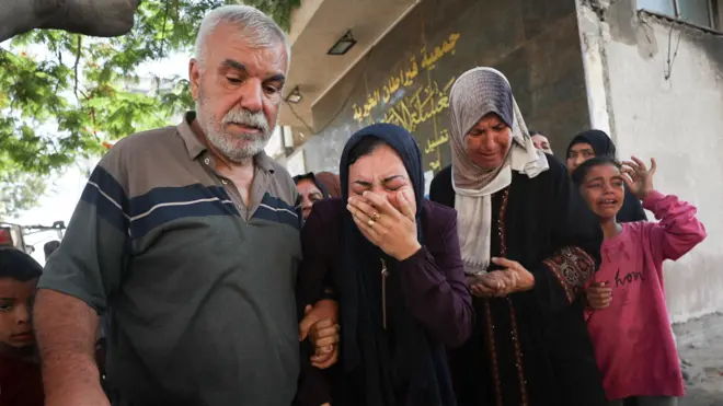 صورة لفلسطينيين يبكون خلال جنازة شخص قُتل خلال سعيه للحصول على مساعدات في قطاع غزة.