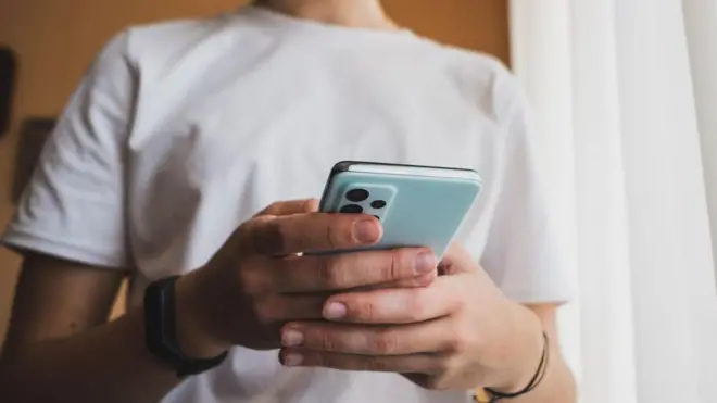 طفل يمسك بهاتف محمول