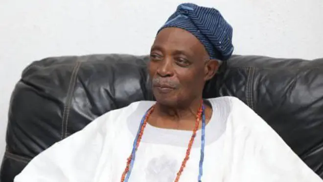 Olubadan ti ilẹ Ibadan, Ọba Rashidi Ladoja, wọ agbada funfun pẹlu ilẹkẹ oye lọrun ati fila lori