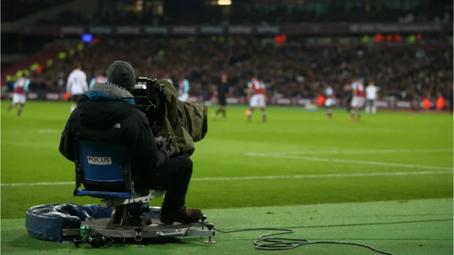 A cameraman films a Premier League game