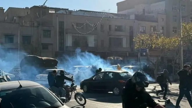 Pessoas na rua em meio a uma fumaça