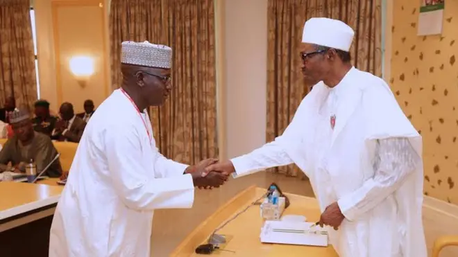 Muhamma M. Nami (left) dey collect hand shake from President Buhari (right)