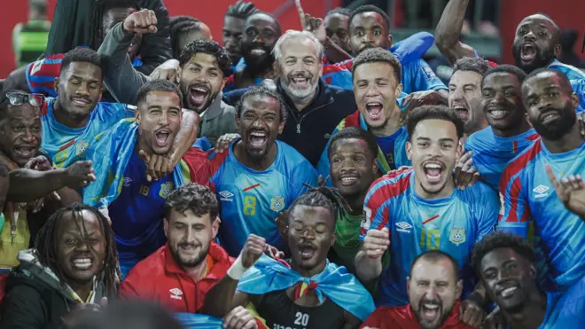 Abakinnyi ba DR Congo bari kumwe n'umutoza Sébastien Desabre (wambaye umupira w'umukara inyumna hagati) bishimira intsinzi mu ijoro ryo ku cyumweru