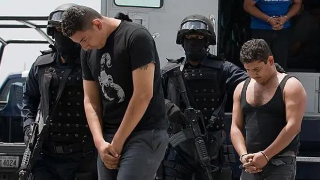 Miembros de La Familia Michoacana esposados son escoltados por las fuerzas de seguridad de México