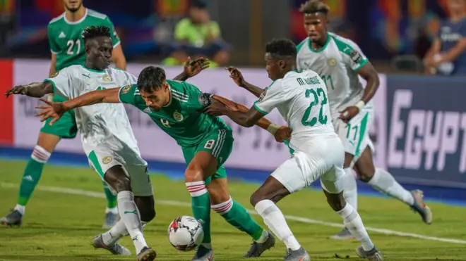 L'Algérien Youcef Belaïli et le Sénégalais Moussa Wagué se disputent le ballon.