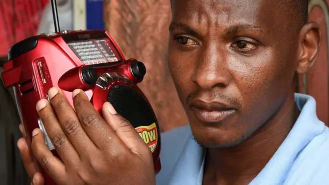 Mwanaume akisikiliza redio kwa makini Uganda