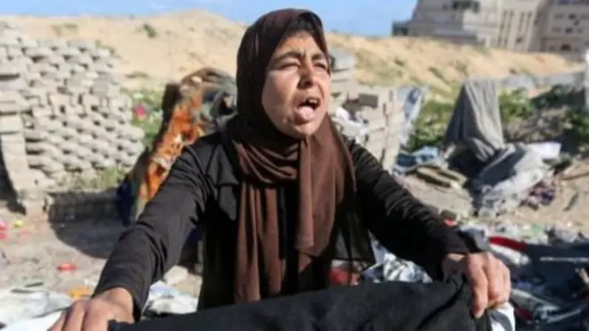 A Palestinian woman sits among wreckage in Khan Younis, southern Gaza Strip. Photo: March 2025