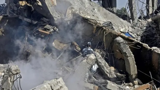 جندي سوري يرش الماء على موقع مركز سوري للابحاث تعرض إلى القصف