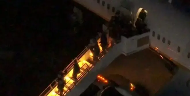 Nicolas Maduro olduğu düşünülen bir kişinin de aralarında bulunduğu büyük bir grup uçaktan iniyor.