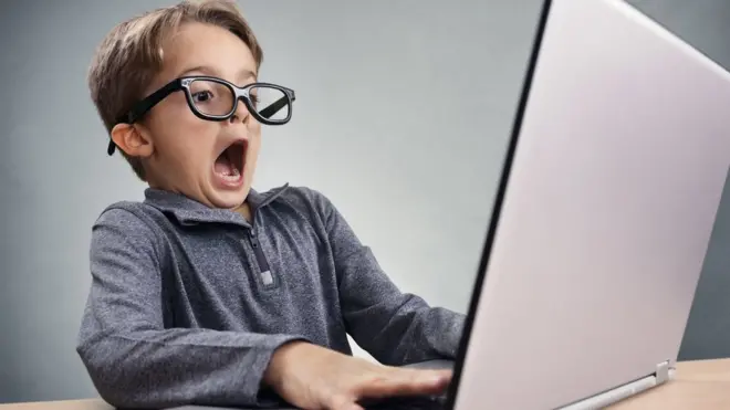 Niño frente a un computador personal