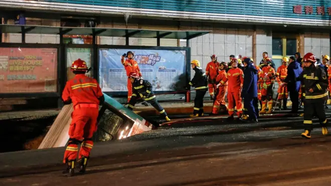 Emergency services work at the site of the sinkhole