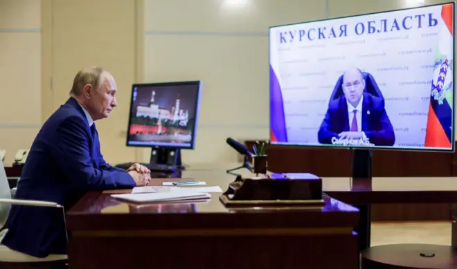 Putin looking in front of two screens
