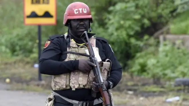 Nigeria police man hold gun tanda for road