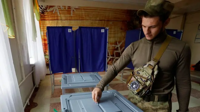 A service member of the self-proclaimed Donetsk People's Republic (DPR) casts his ballot at a polling station during a referendum on the joining of DPR to Russia, in Donetsk, Ukraine 27 September