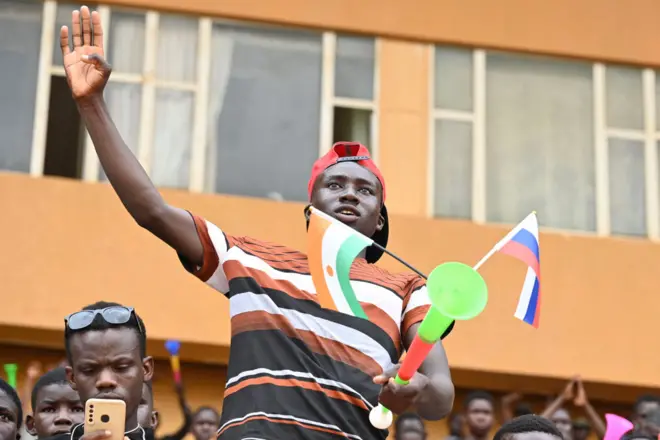 رجل يلوح بعلمي روسيا والنيجر في استاد الجنرال سيني كونتشي في العاصمة نيامي، 13 أغسطس/آب 2023