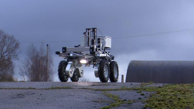 Сельскохозяйственный робот едет по дороге
