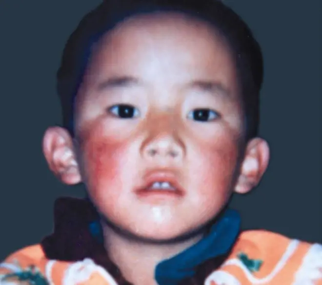 Close-up image of Gedhun Choekyi Nyima with reddish cheeks and looking straight into the camera. He was six when he disappeared. 