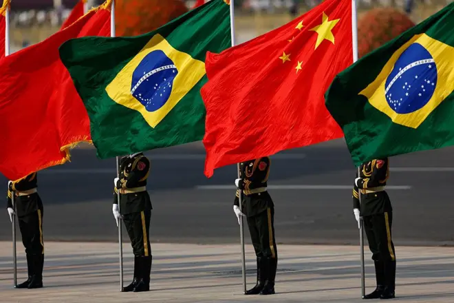 Membros da guarda de honra seguram bandeiras nacionais da China e do Brasil antes de uma cerimônia de boas-vindas ao presidente brasileiro Luiz Inácio Lula da Silva no Grande Salão do Povo em Pequim, em 13 de maio de 2025